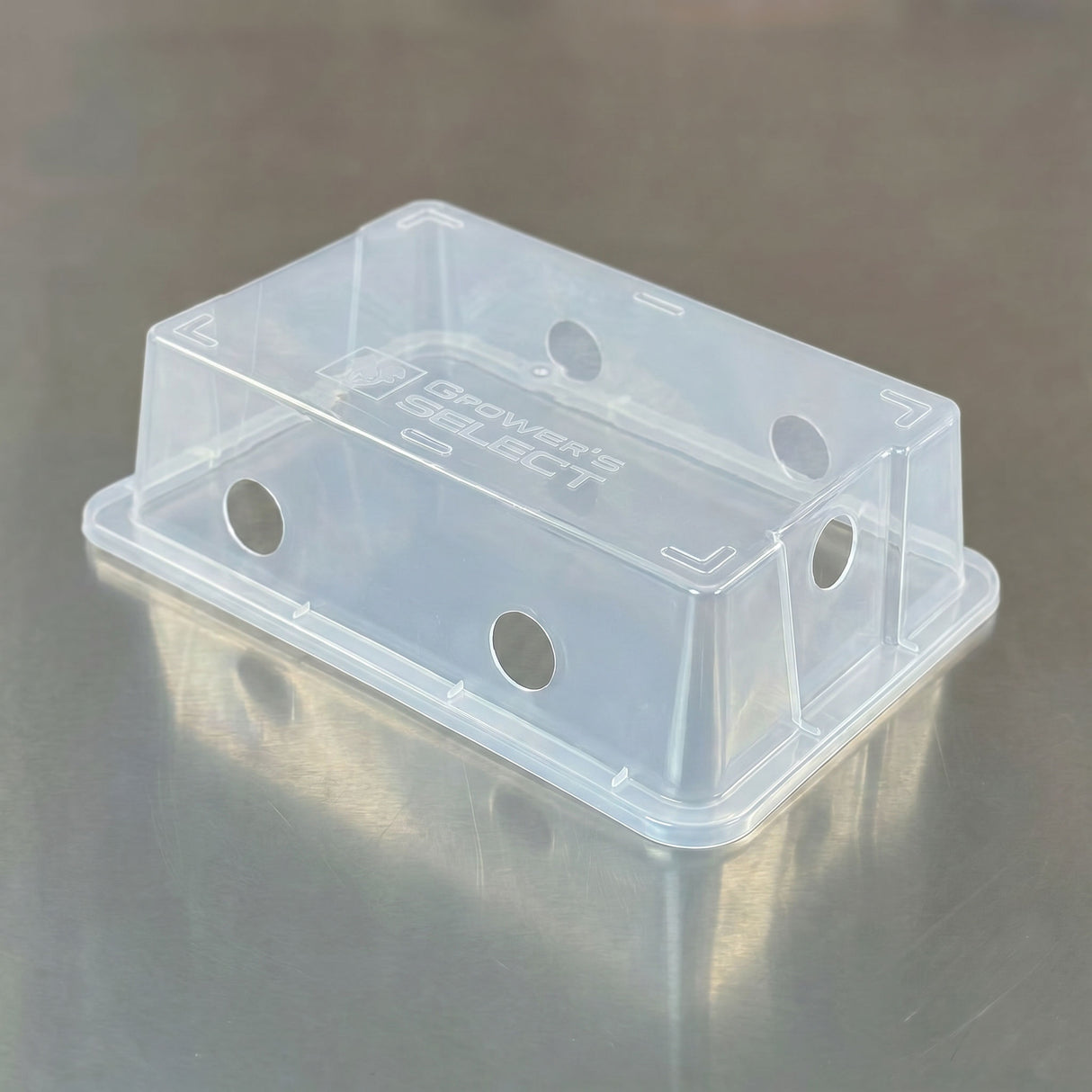 Clear plastic container with 'Growers' Edge' branding on a reflective surface