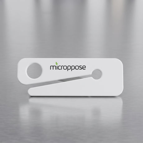 Microppose bag opener with recessed stainless steel blade on a stainless work surface