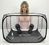 Person wearing black gloves and a pink shirt inside a transparent Myco Labs tent on a white background