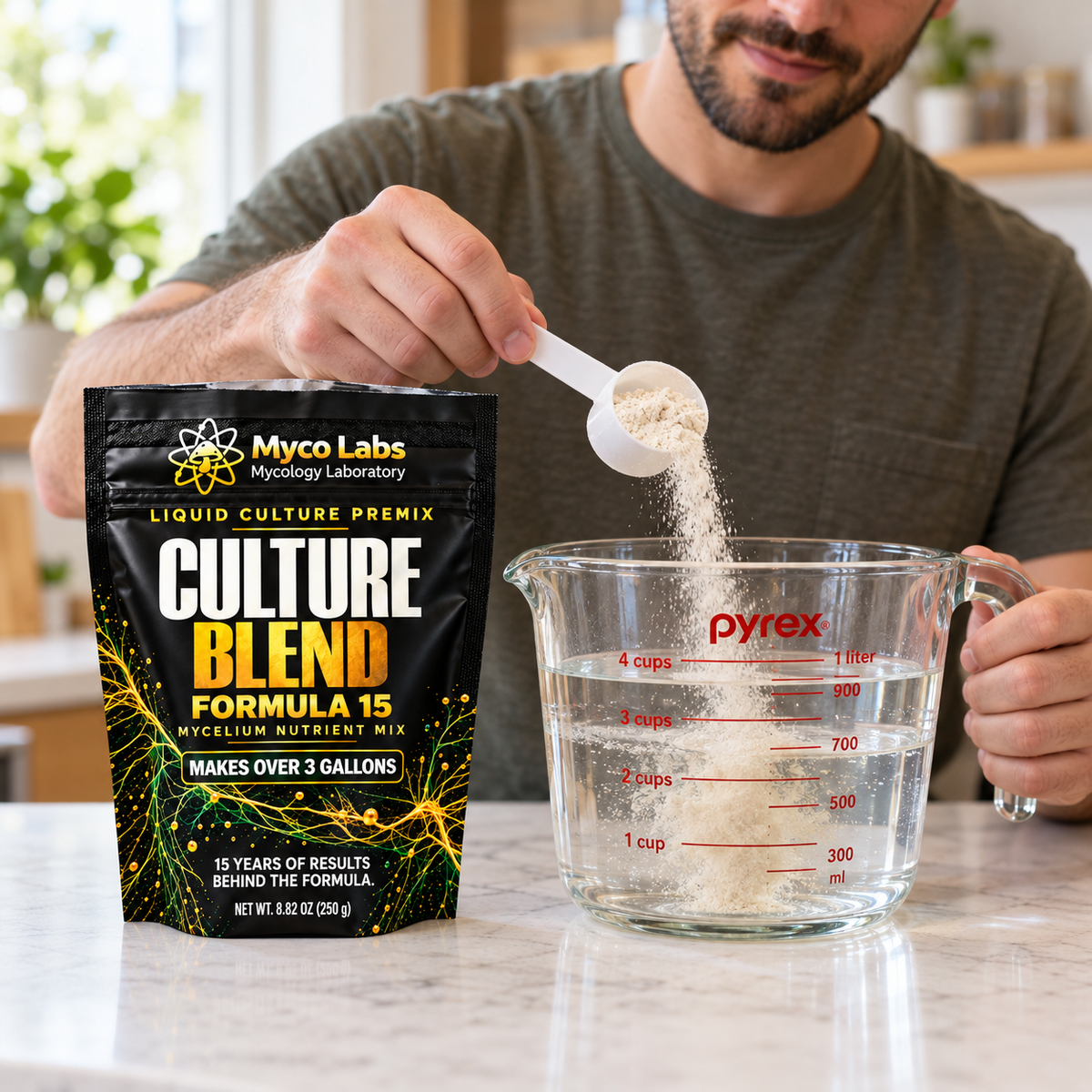 A man scooping Myco Labs Liquid Culture Premix into a pyrex measuring cup on kitchen counter. 