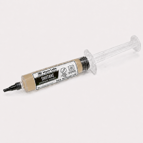 A syringe-style container of Shitake Leather Smoker by Myco Labs, filled with beige-colored spore powder, shown on a light gray background.